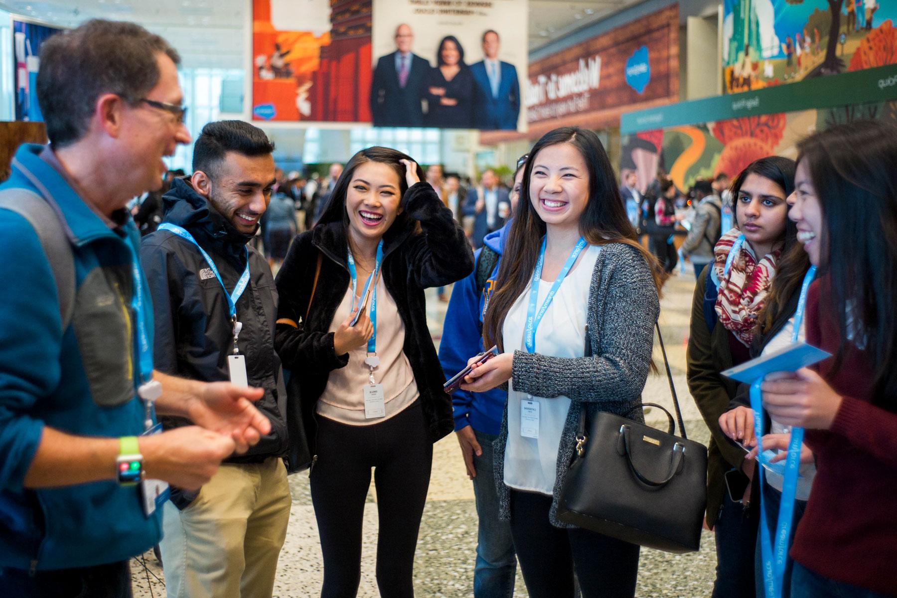 Students laughing while chatting at a Salesforce conference.
