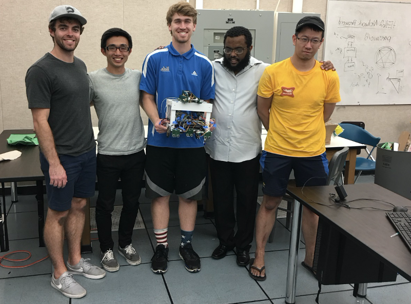 Samuel Semahegn和他的UCLA团队站在一起，手里拿着一个机器人原型.