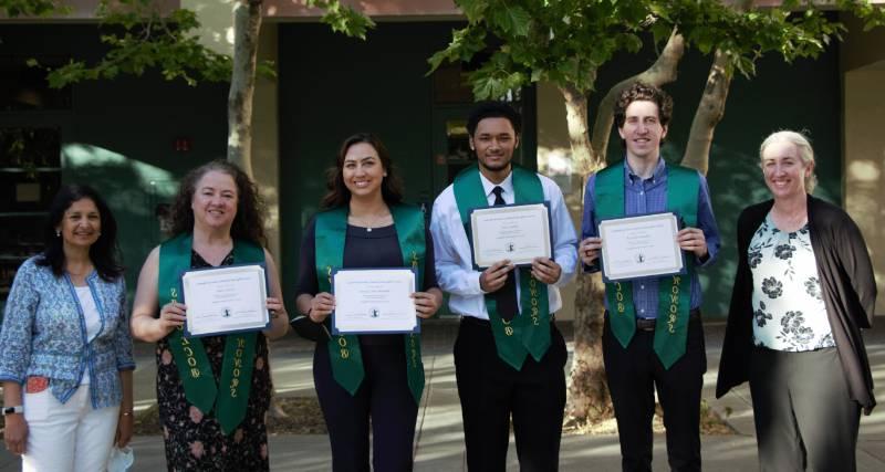 Group of Sbona Grads posing with their stoles and certificates