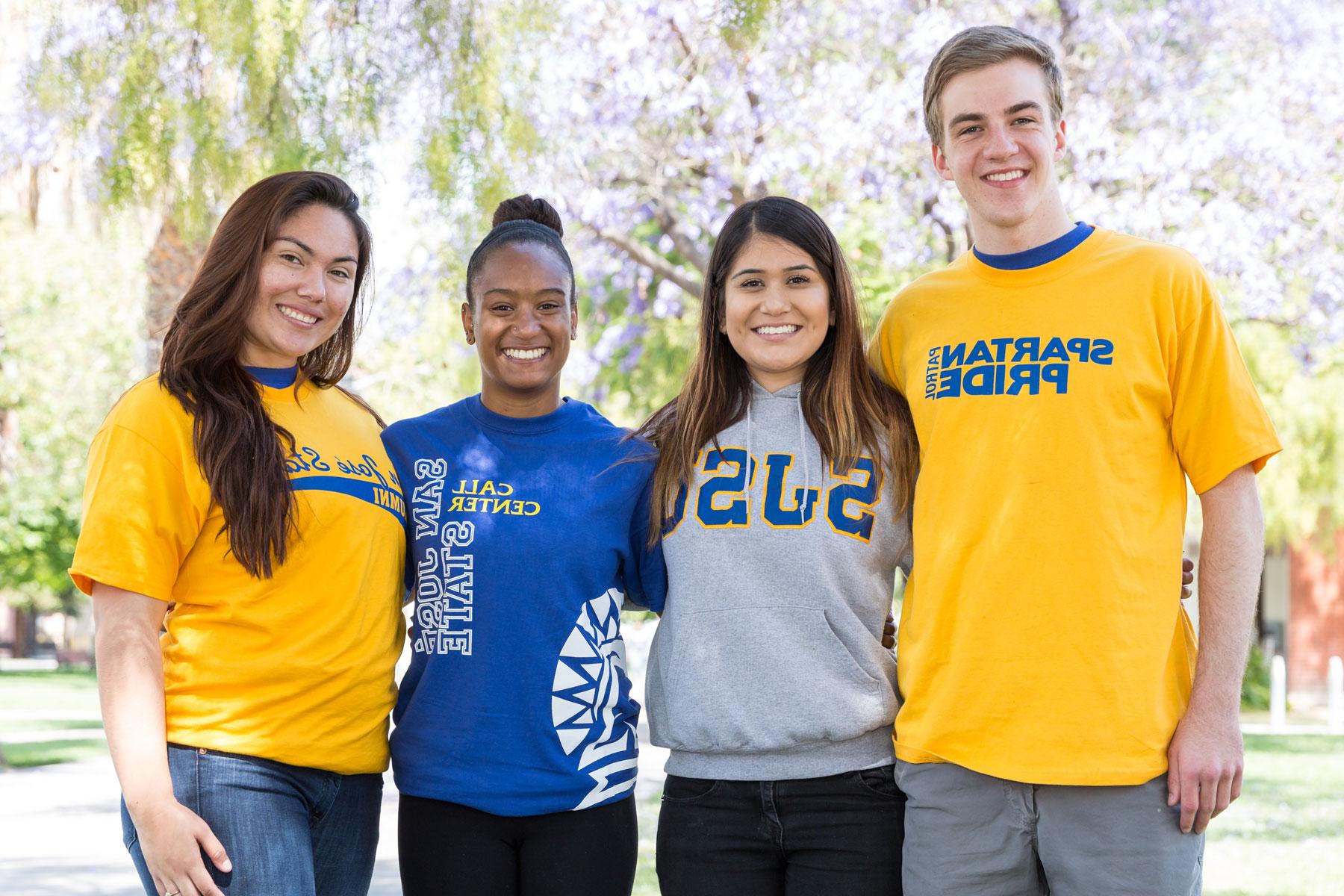 四名身着圣何塞州立大学斯巴达衫的学生微笑着摆姿势拍照. 