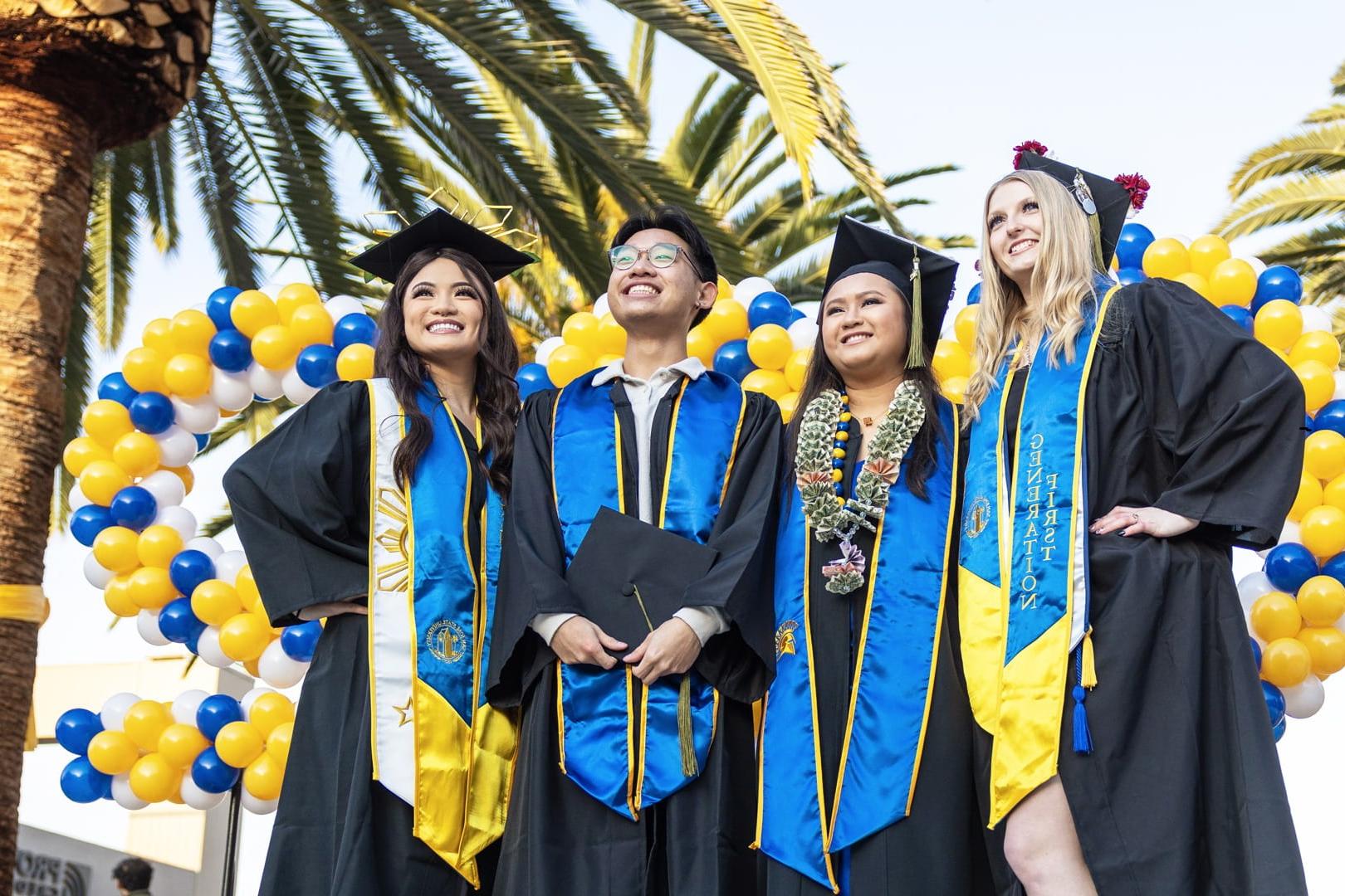 一群圣何塞州立大学的毕业生戴着毕业帽，穿着毕业服，摆姿势拍照. 