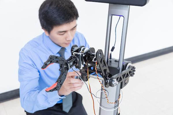 Student adjusting a robotic arm